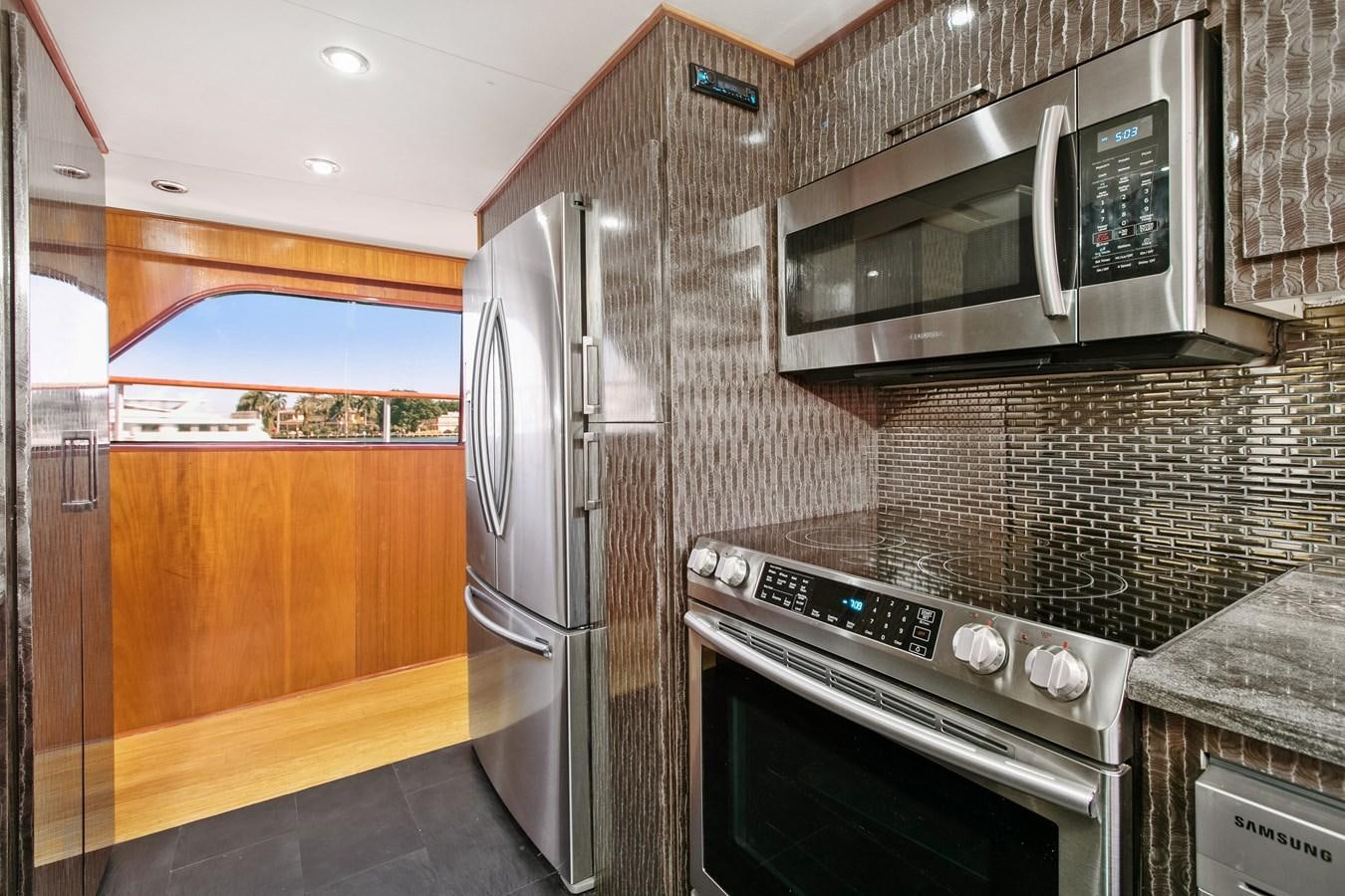 a kitchen with a stainless steel microwave oven and a stainless steel oven aboard TRES HERMANOS VI Yacht for Sale