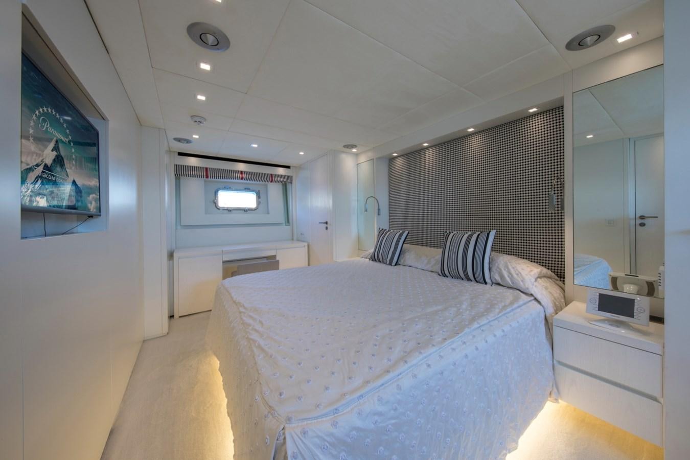 a bedroom with a bed and a tv on the wall aboard MAI Yacht for Sale