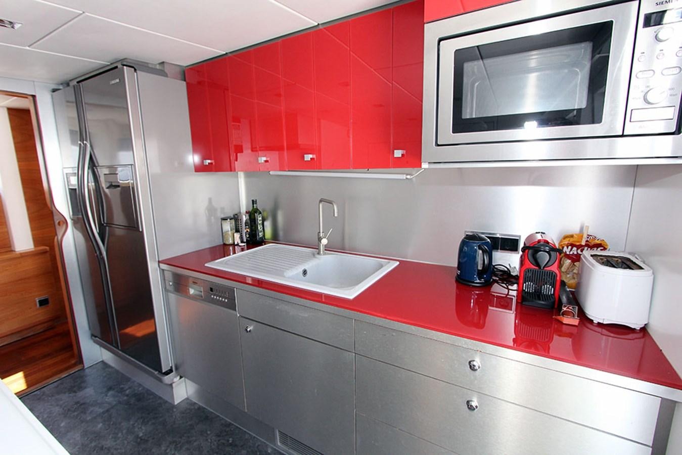 a kitchen with red cabinets aboard HAIGAN Yacht for Sale
