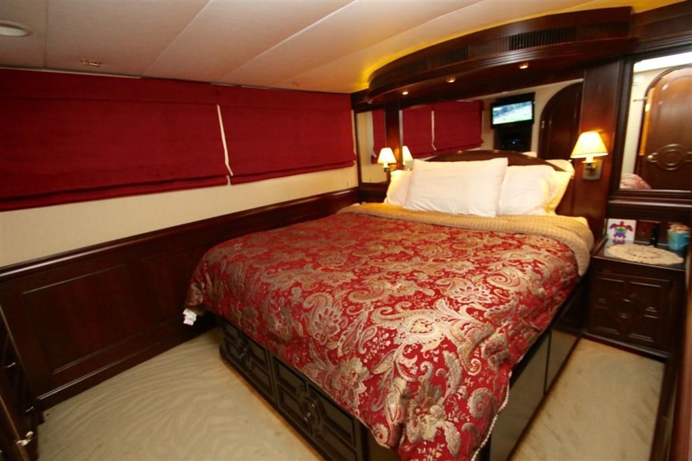 a bed with red sheets aboard ROSA Yacht for Sale