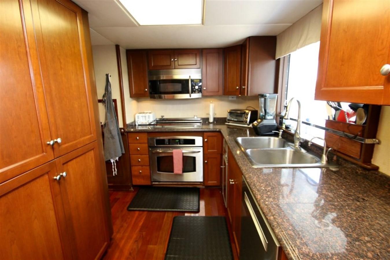 a kitchen with wooden cabinets aboard ROSA Yacht for Sale
