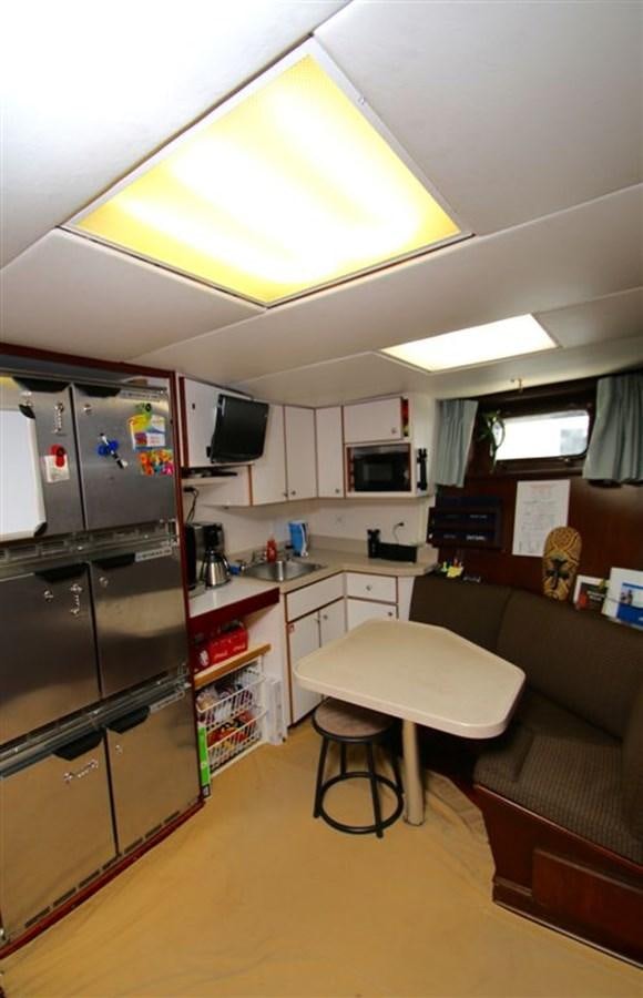 a kitchen with a black refrigerator aboard ROSA Yacht for Sale