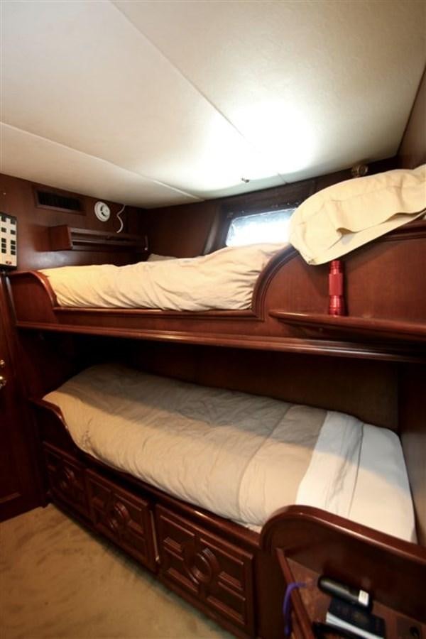 a bed with a wooden headboard aboard ROSA Yacht for Sale