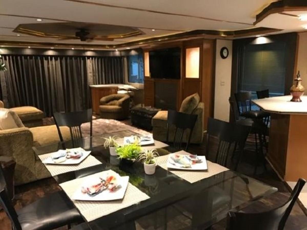 a living room with a table and chairs aboard FANTASY HOUSEBOAT Yacht for Sale
