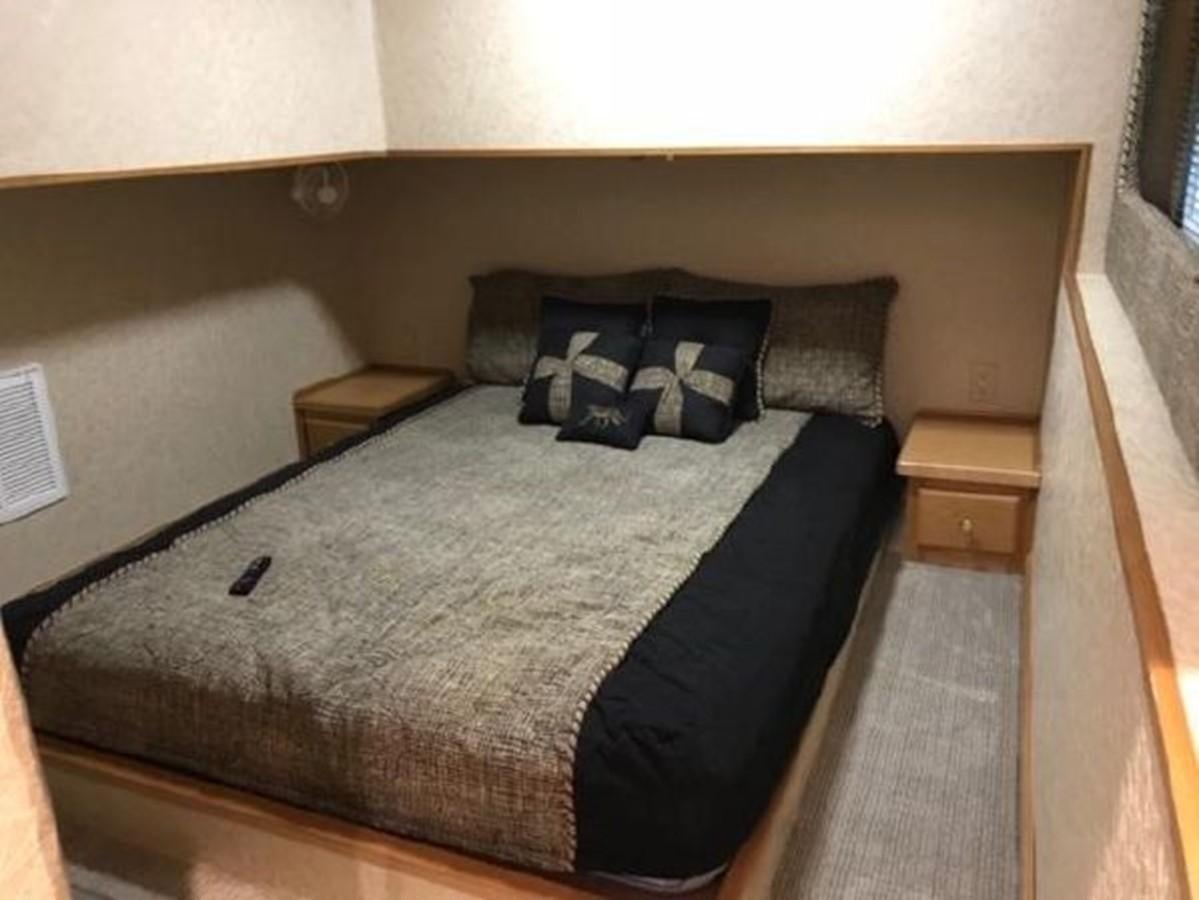 a bed with a black and white comforter and pillows aboard FANTASY HOUSEBOAT Yacht for Sale