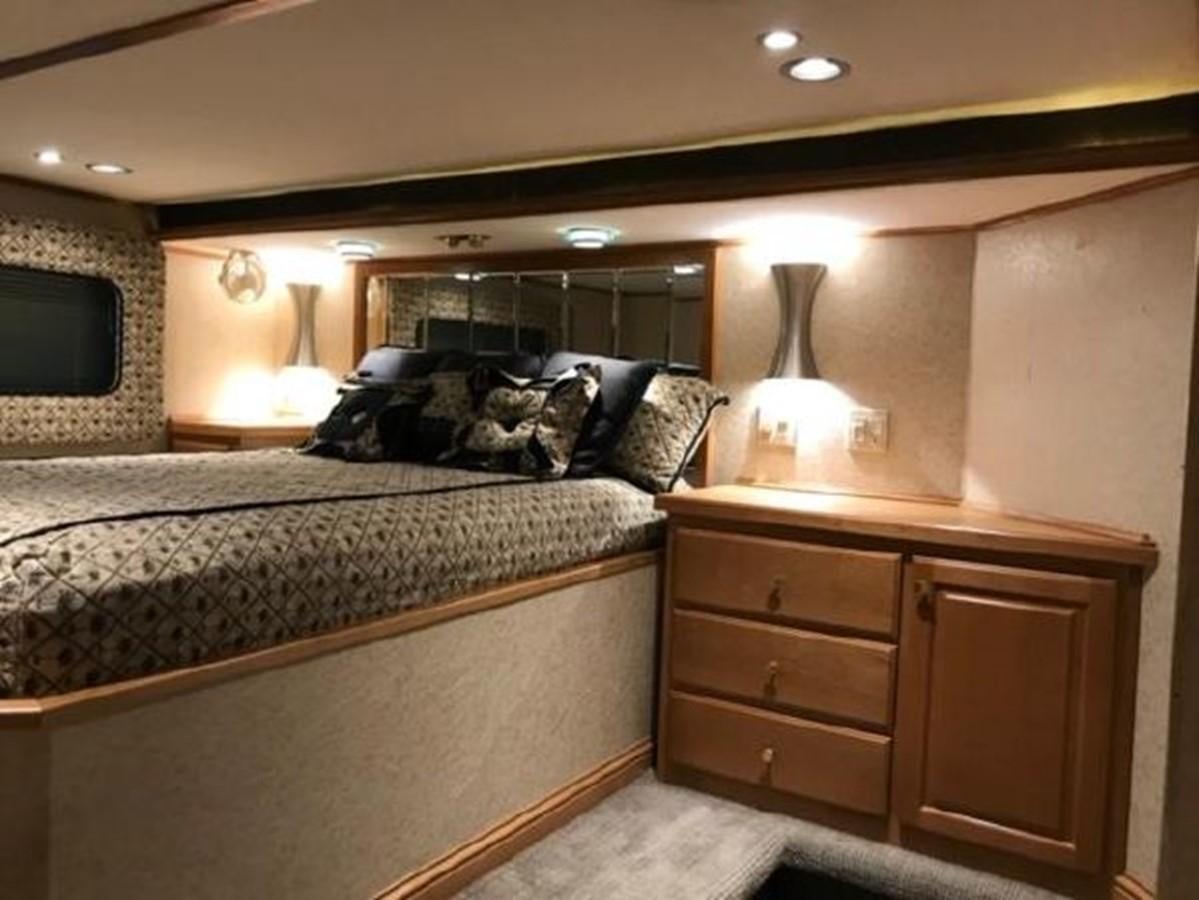 a bedroom with a bed and a dresser aboard FANTASY HOUSEBOAT Yacht for Sale