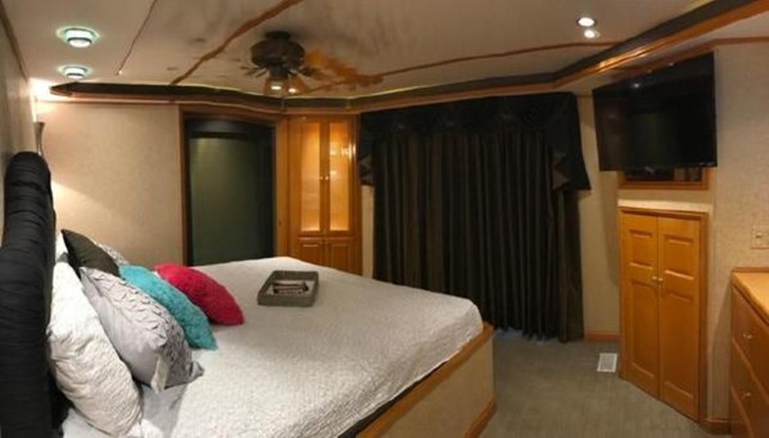 a bedroom with a bed and a television aboard FANTASY HOUSEBOAT Yacht for Sale