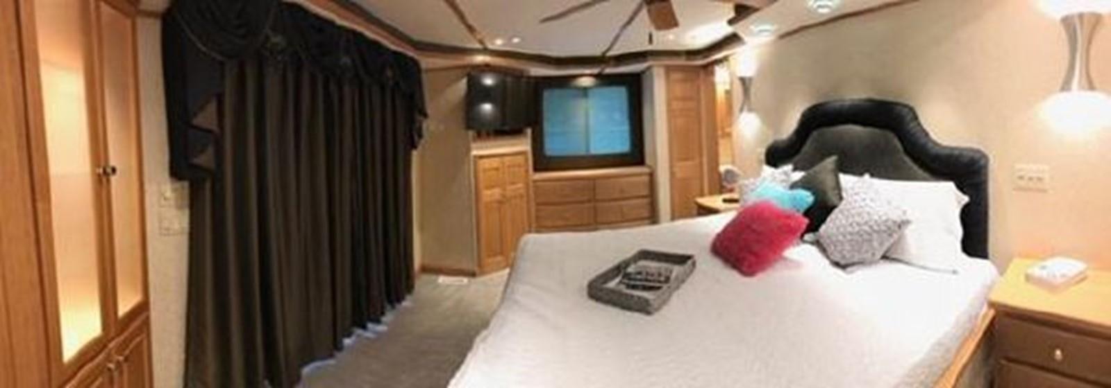 a bedroom with a bed and a desk aboard FANTASY HOUSEBOAT Yacht for Sale