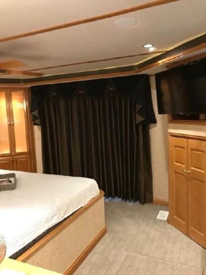 a bedroom with a black curtain aboard FANTASY HOUSEBOAT Yacht for Sale