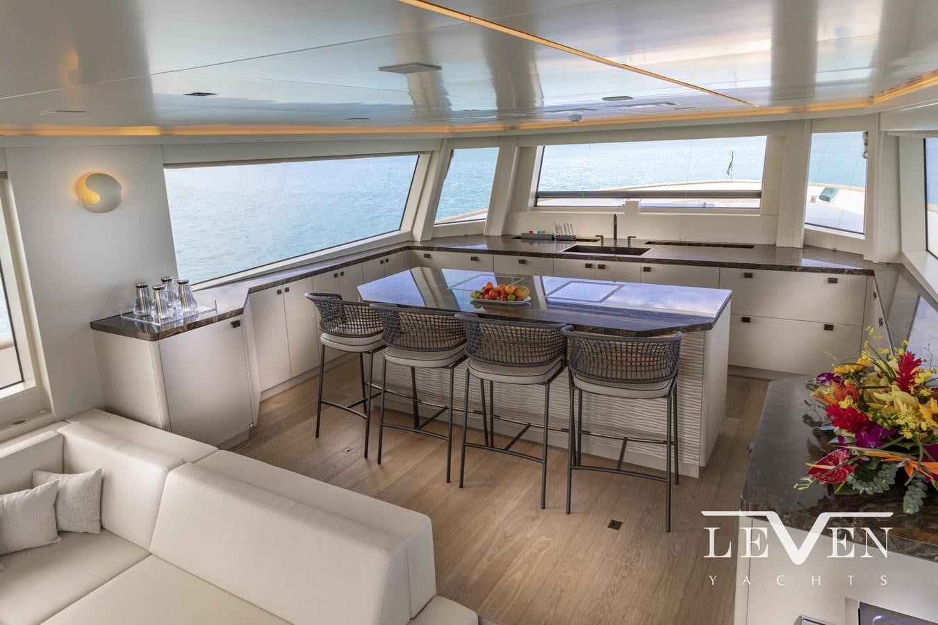 a room with a table chairs and a couch aboard LEVEN 90 LV01 Yacht for Sale