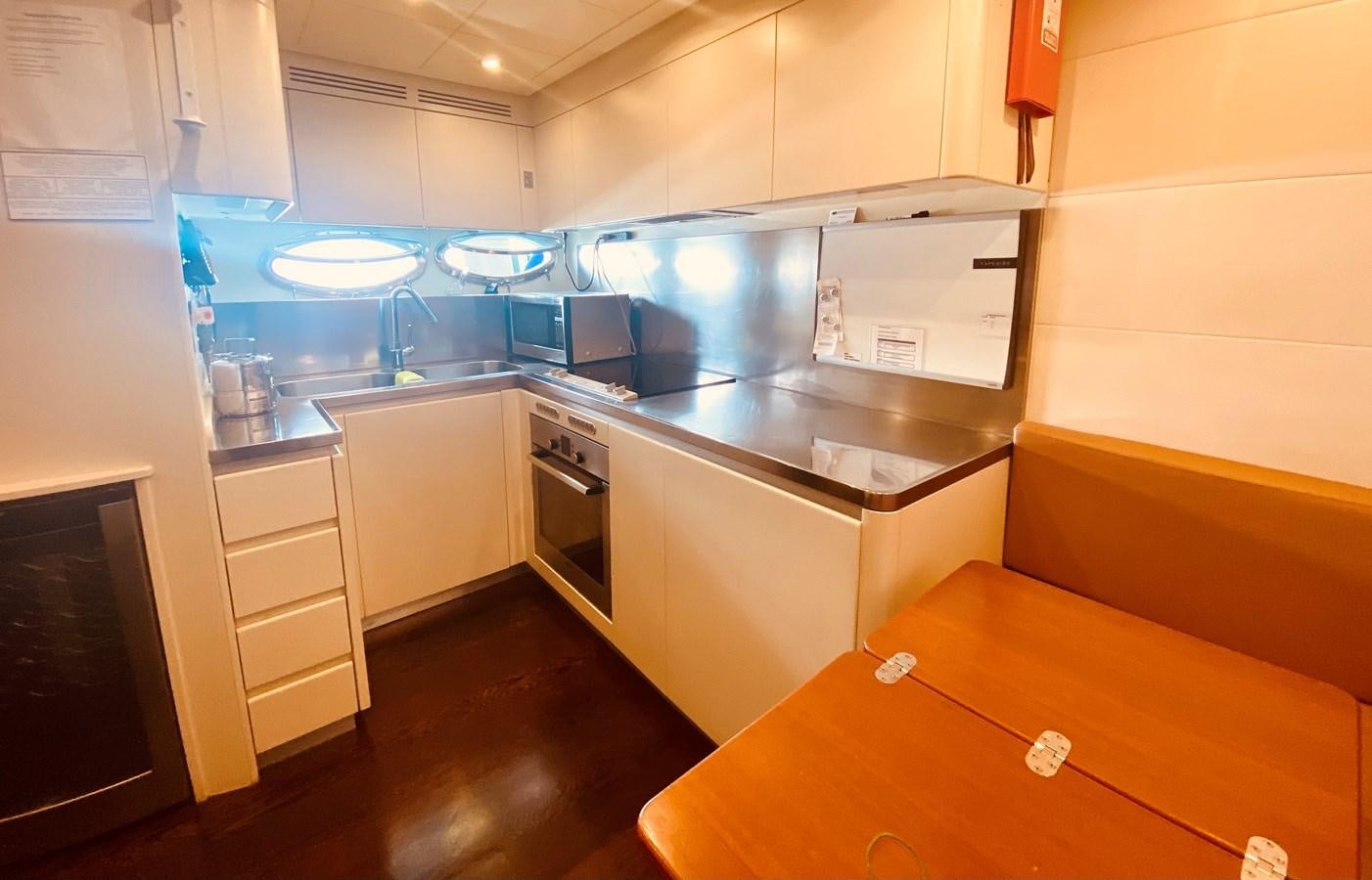 a kitchen with a table and cabinets aboard ROMPEMAR Yacht for Sale