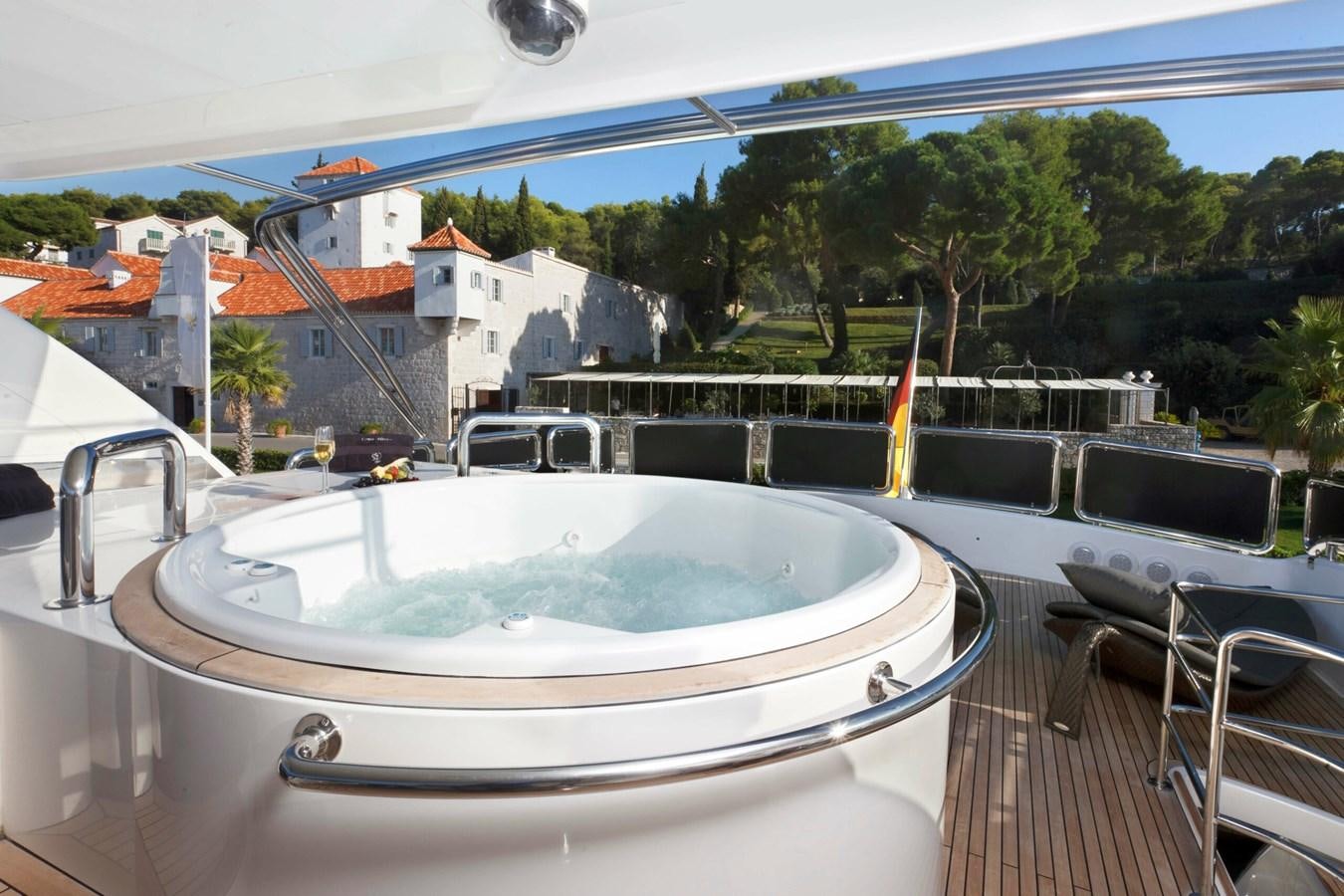 a white trampoline on a deck with a pool and houses aboard CONTE ALBERTI Yacht for Sale