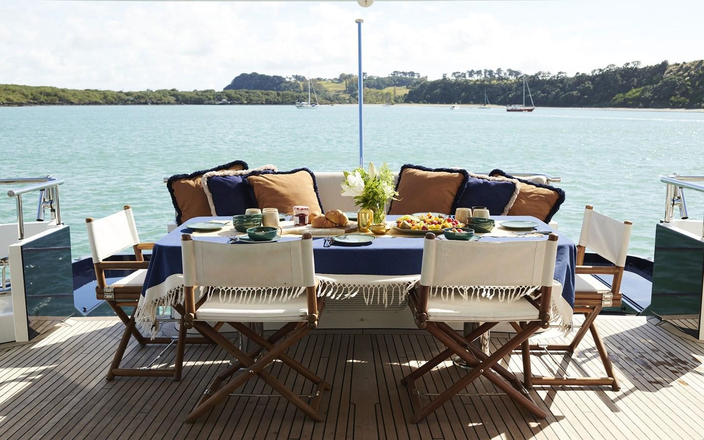 a table set up on a deck overlooking a body of water aboard WILLOW Yacht for Sale