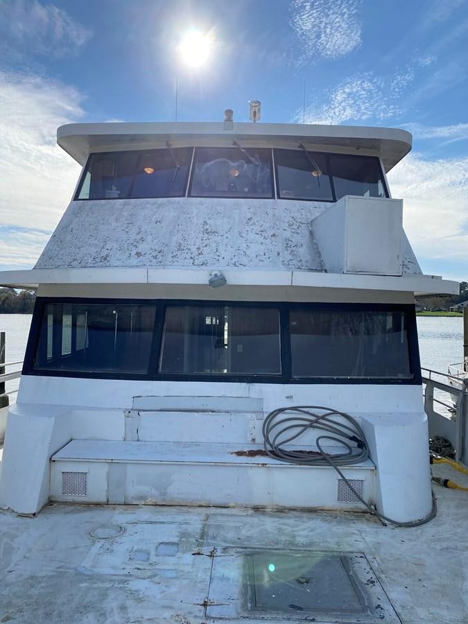 a white house with a bicycle on the roof aboard THE OASIS Yacht for Sale
