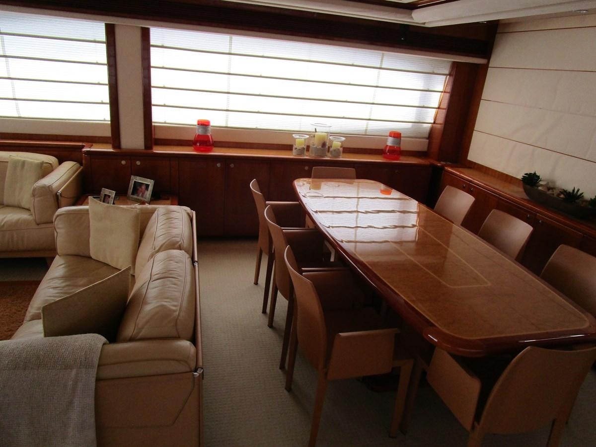 a room with a table and chairs aboard NACL Yacht for Sale