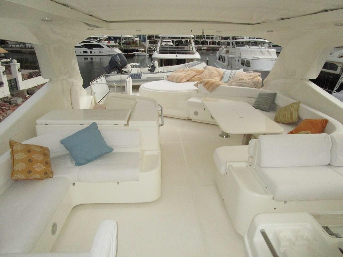 a room with several white couches aboard NACL Yacht for Sale
