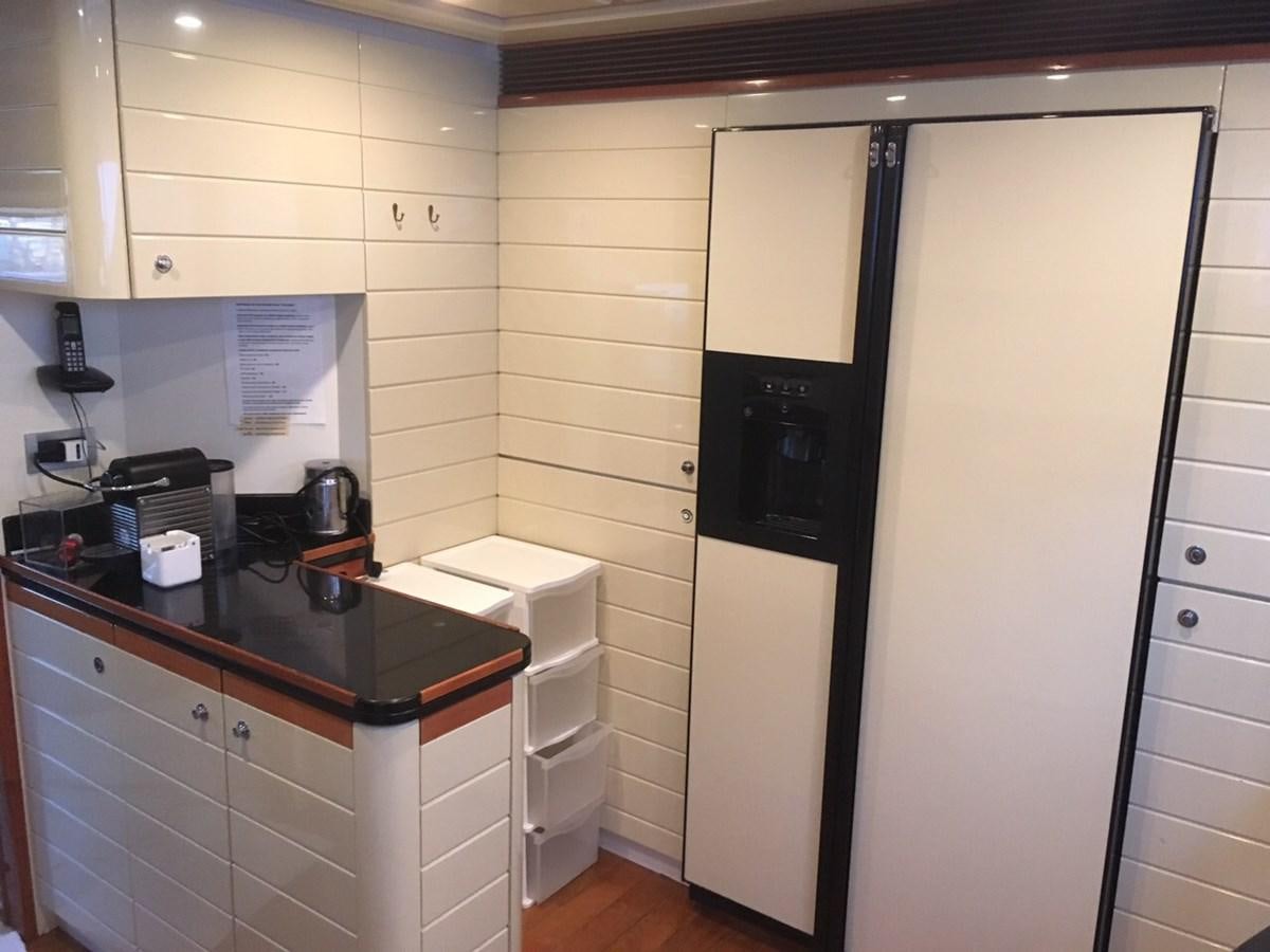 a kitchen with a refrigerator and a microwave aboard LADY VICTORIA Yacht for Sale