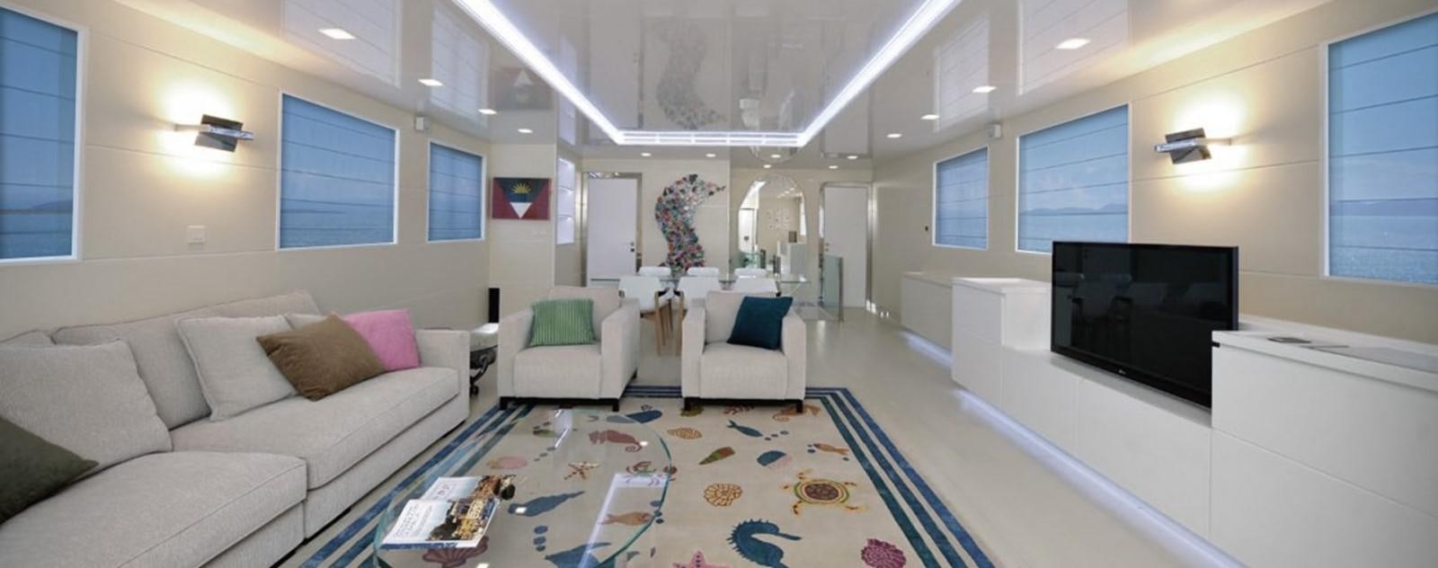 a living room with a blue and white rug aboard OCEAN KING 88 Yacht for Sale