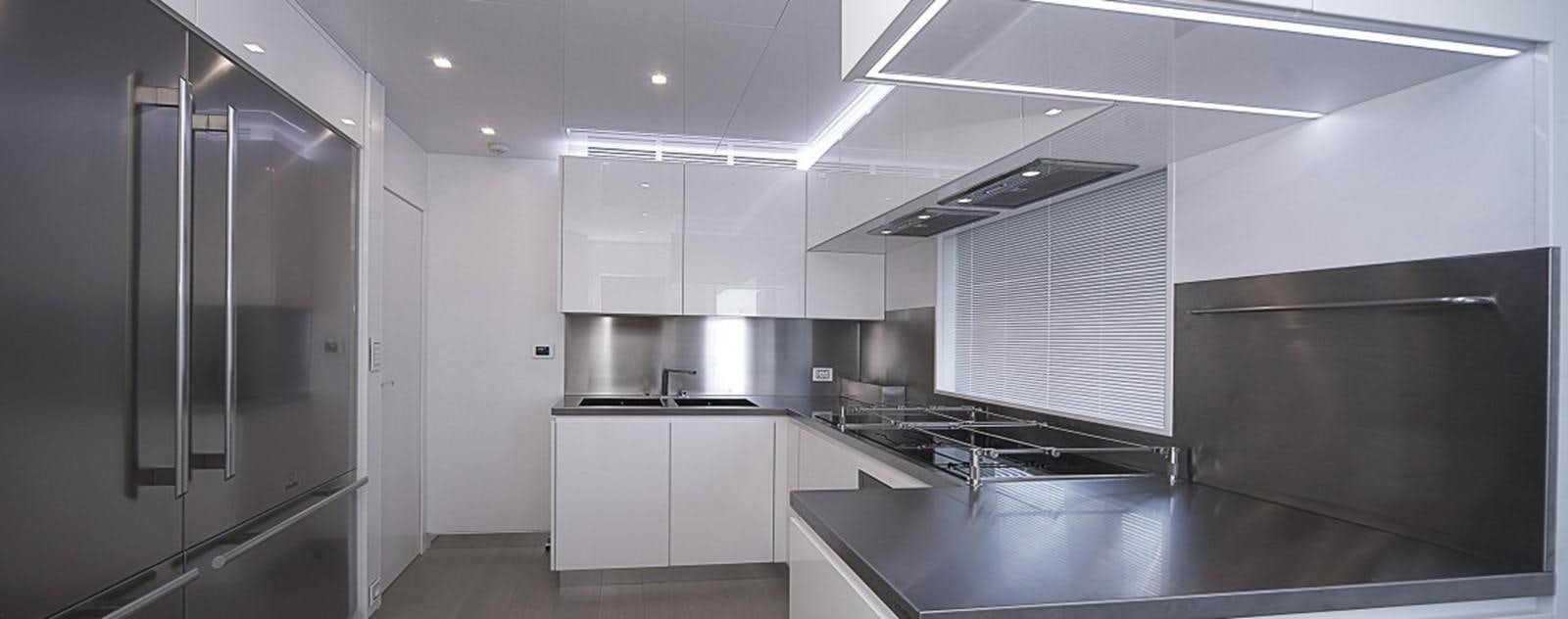 a kitchen with white cabinets aboard OCEAN KING 88 Yacht for Sale