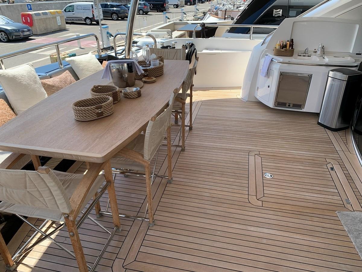 a wooden table with chairs and a microwave on it aboard KAPUSHA Yacht for Sale