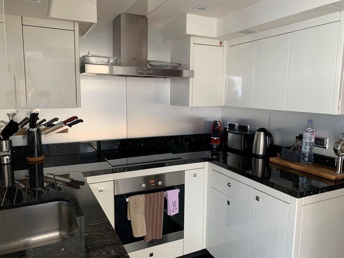 a kitchen with white cabinets aboard KAPUSHA Yacht for Sale