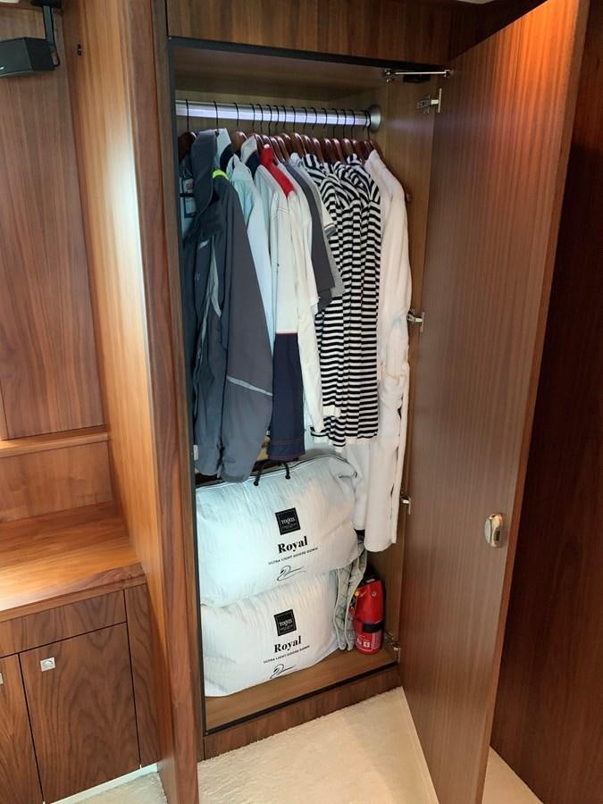 a closet with clothes on the wall aboard KAPUSHA Yacht for Sale