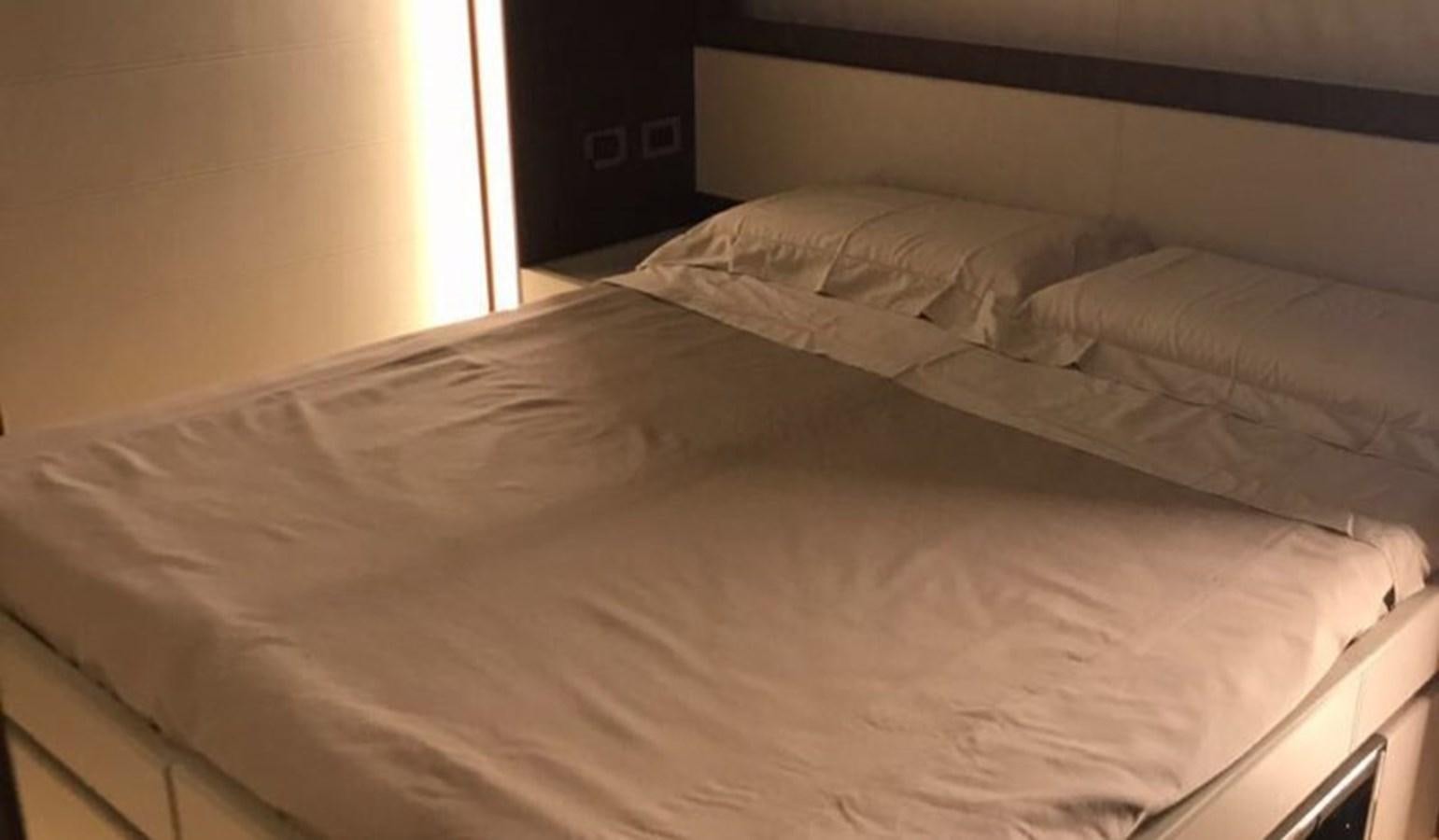 a bed with white sheets aboard DOMINO Yacht for Sale
