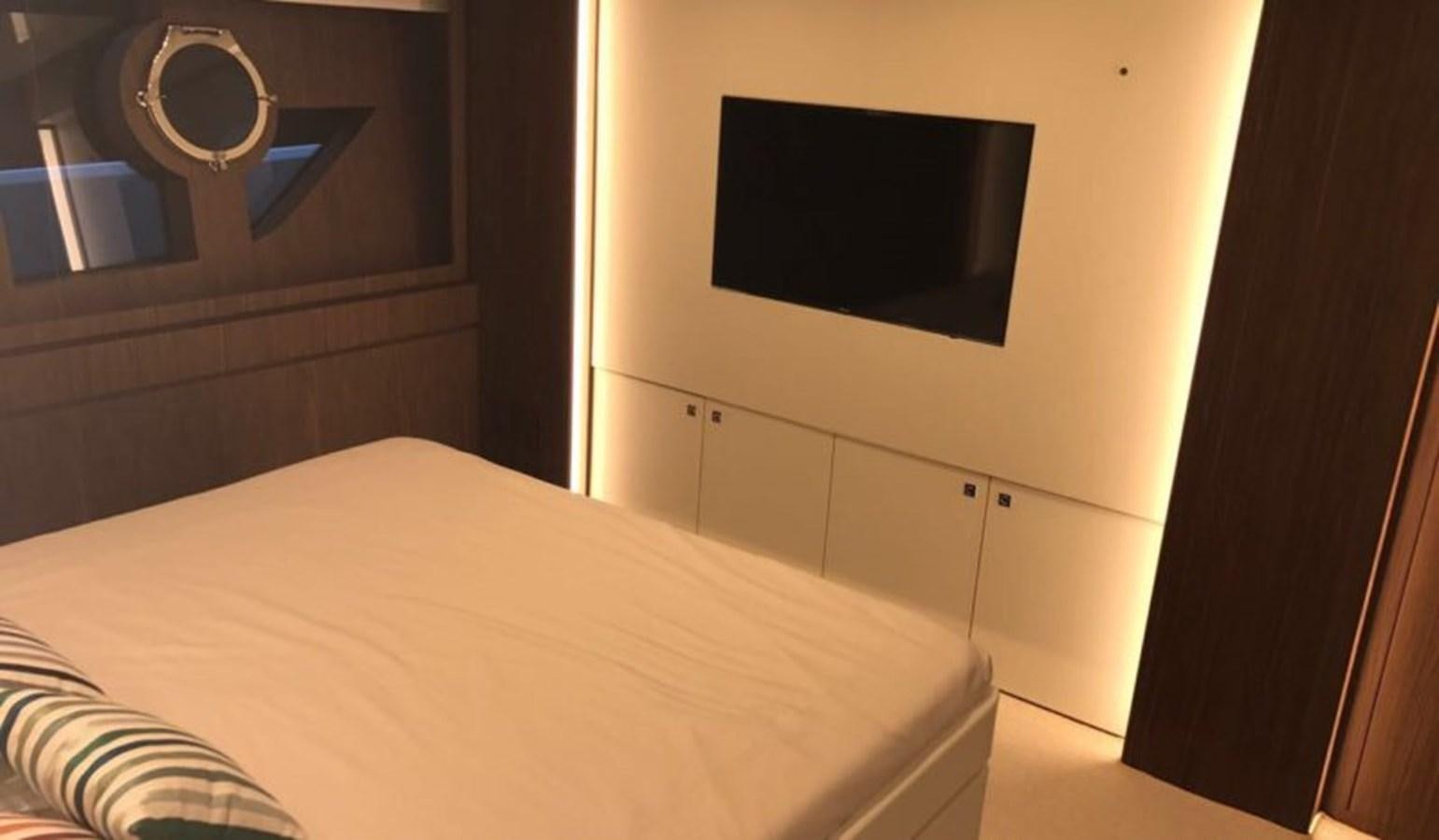 a bed with a television on the wall aboard DOMINO Yacht for Sale