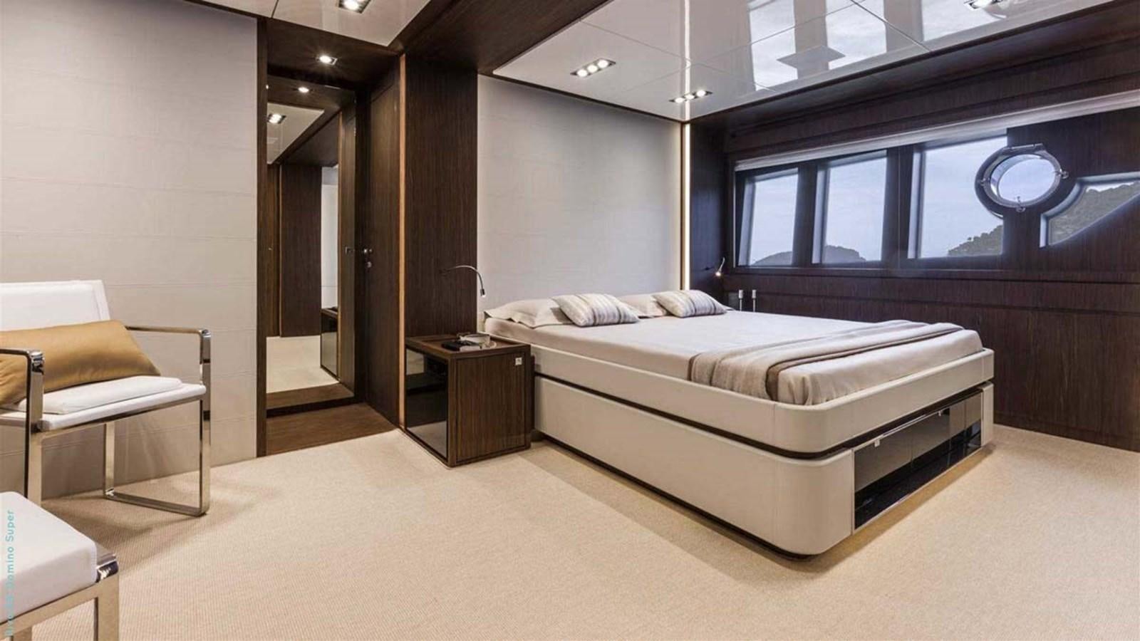 a bedroom with a bed and a chair aboard FIRST SIGNS Yacht for Sale