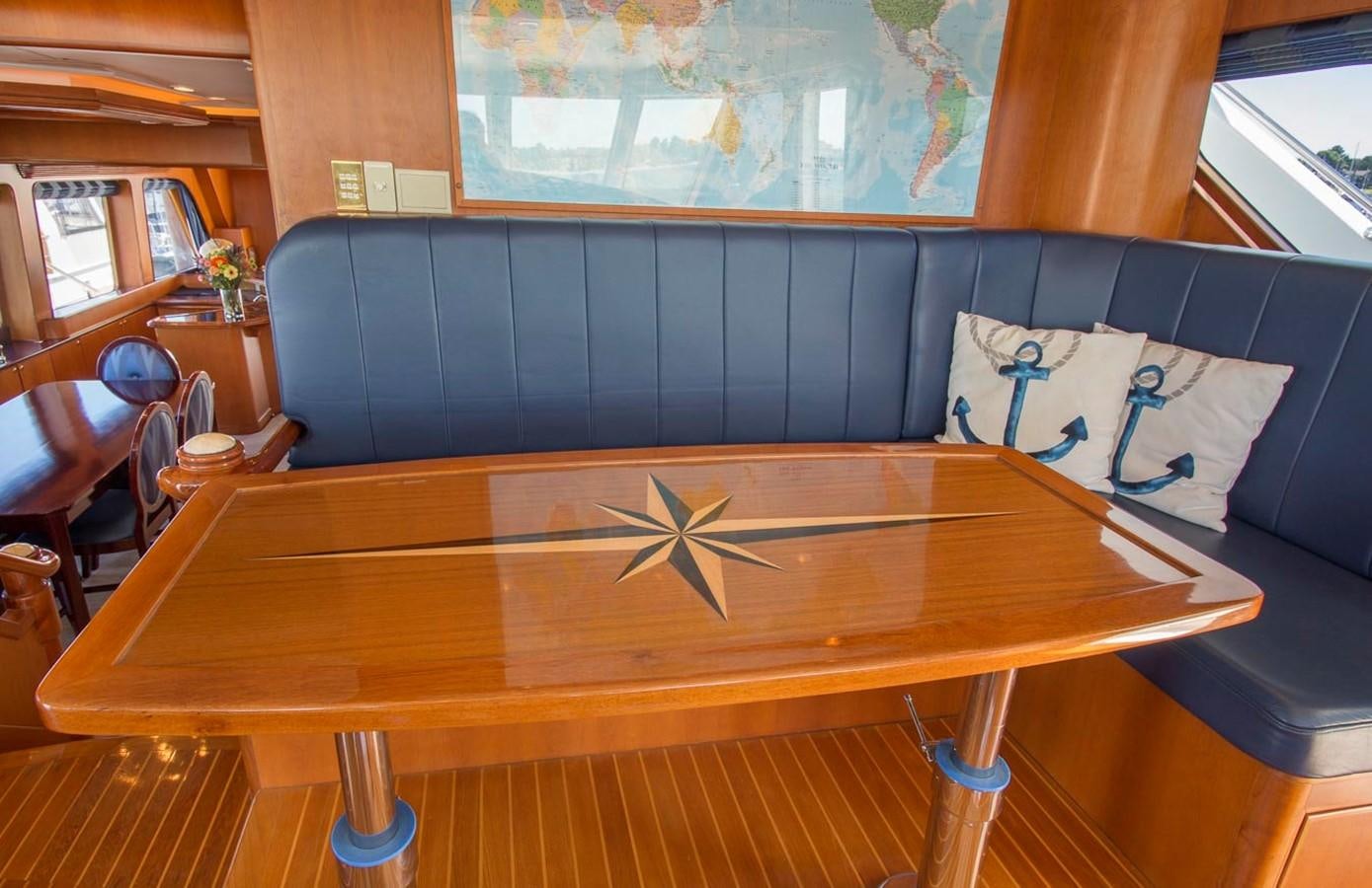 a wood table with a blue and white pillow on it aboard SILVER WINGS Yacht for Sale