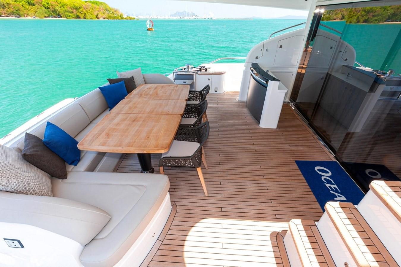 a deck with a table and chairs on it aboard OCEAN Yacht for Sale