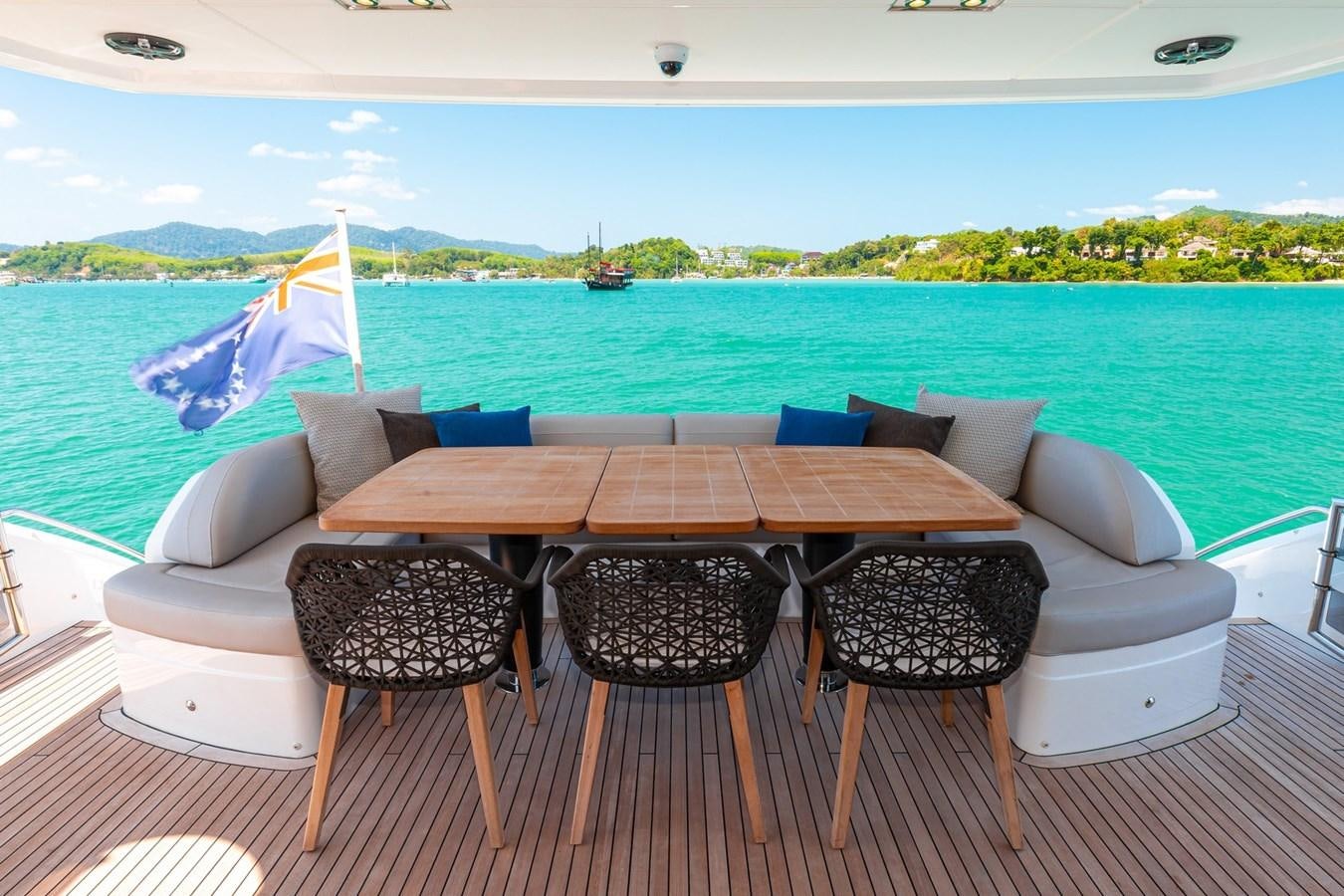a table and chairs on a deck overlooking a body of water aboard OCEAN Yacht for Sale