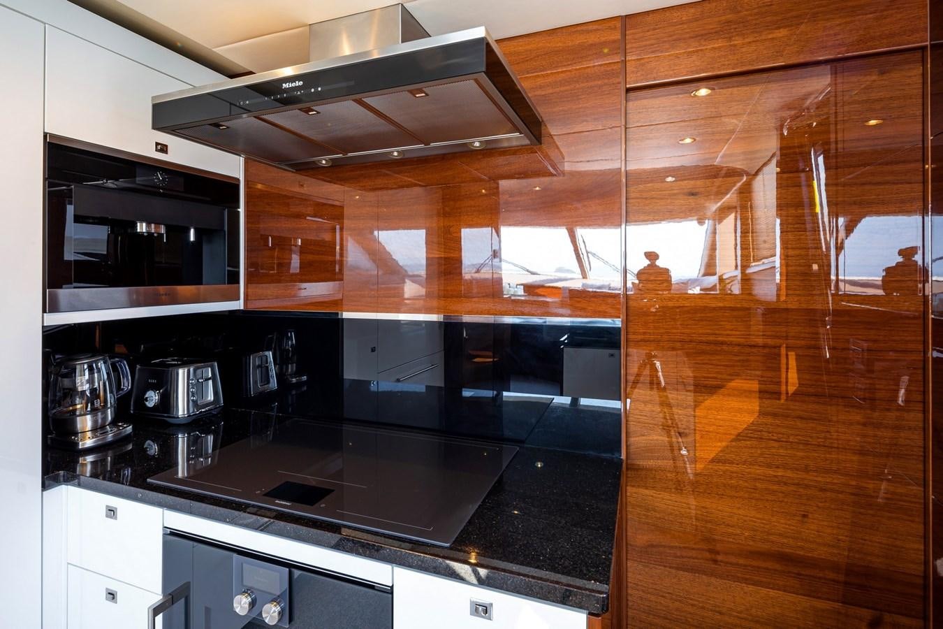 a kitchen with a stove and a microwave aboard OCEAN Yacht for Sale