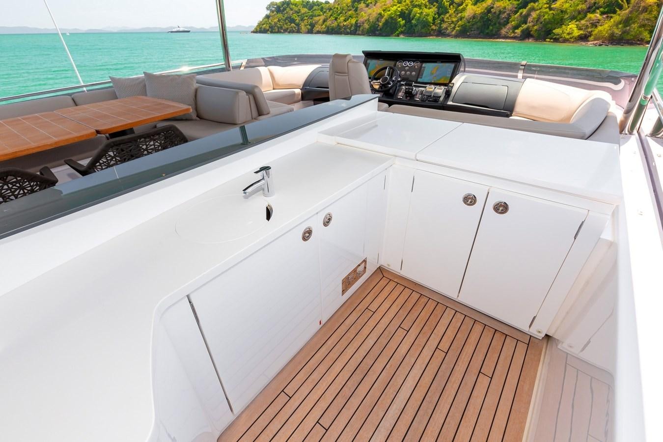 a white kitchen with a wood deck aboard OCEAN Yacht for Sale