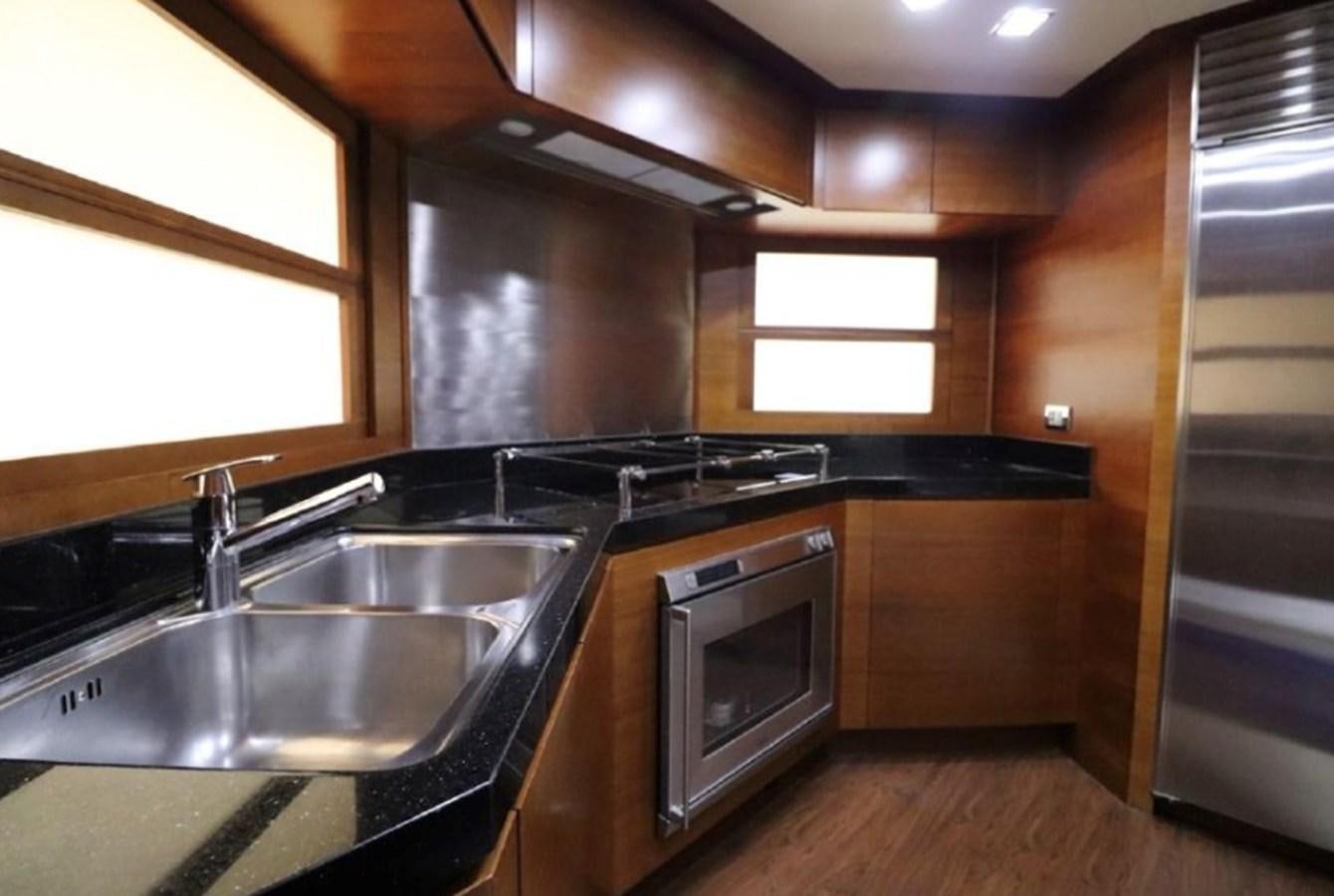 a kitchen with wooden cabinets aboard AZIMUT AZ 85/124 Yacht for Sale