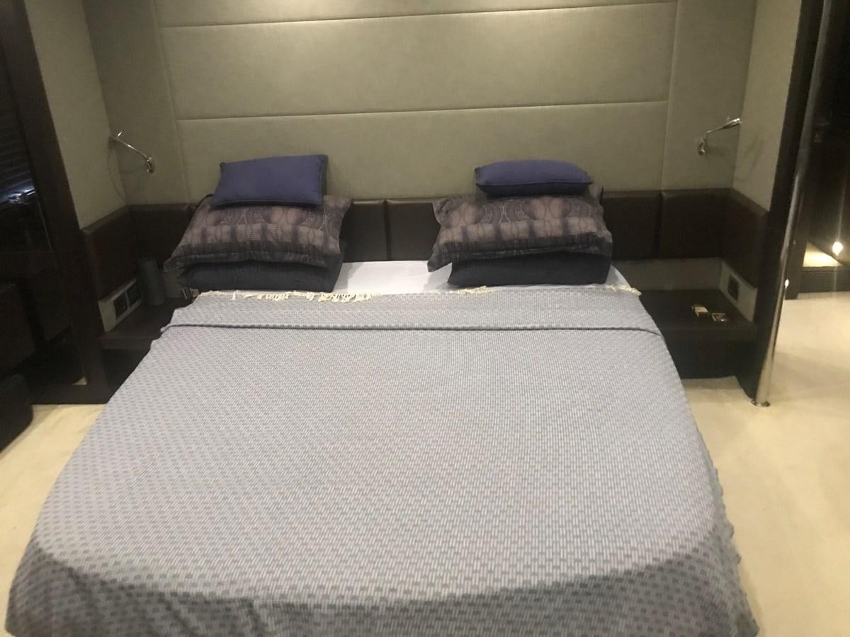 a bed with a blue pillow aboard PATRIOT Yacht for Sale