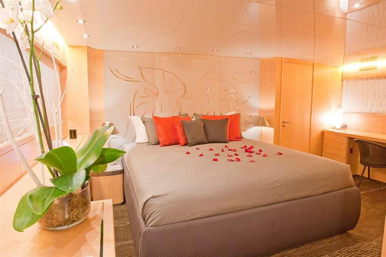 a bed with a plant on the side aboard COCA VI Yacht for Sale