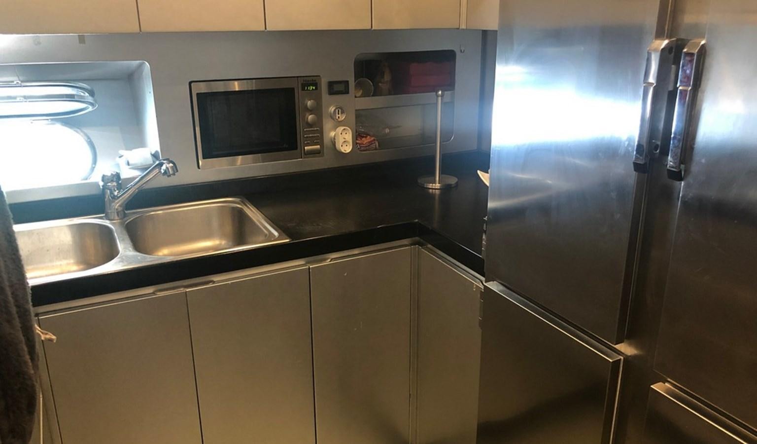 a kitchen with a stainless steel refrigerator aboard AYA Yacht for Sale