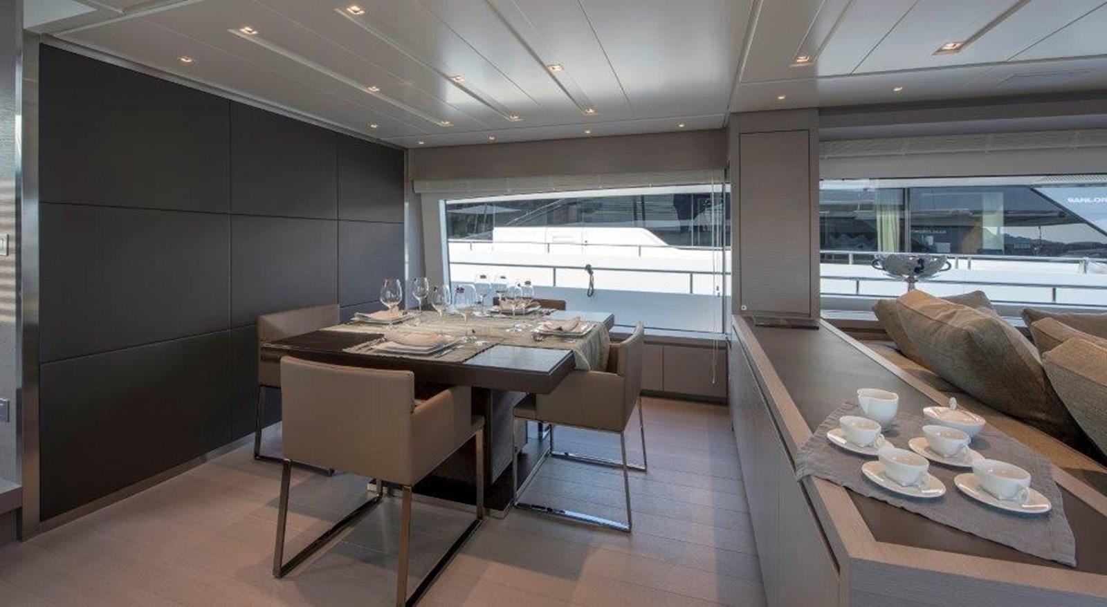 a modern looking kitchen with a dining table and chairs aboard MAJOLA Yacht for Sale