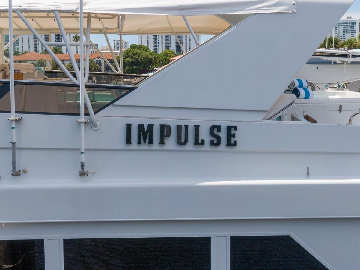 a white boat with a sign on the front aboard UNLEASHED Yacht for Sale