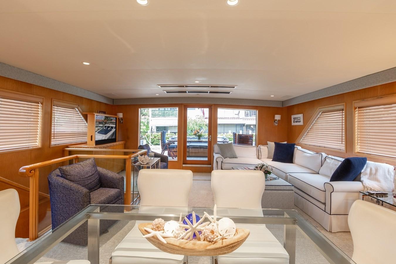 a living room with a large glass table and a couch aboard UNLEASHED Yacht for Sale