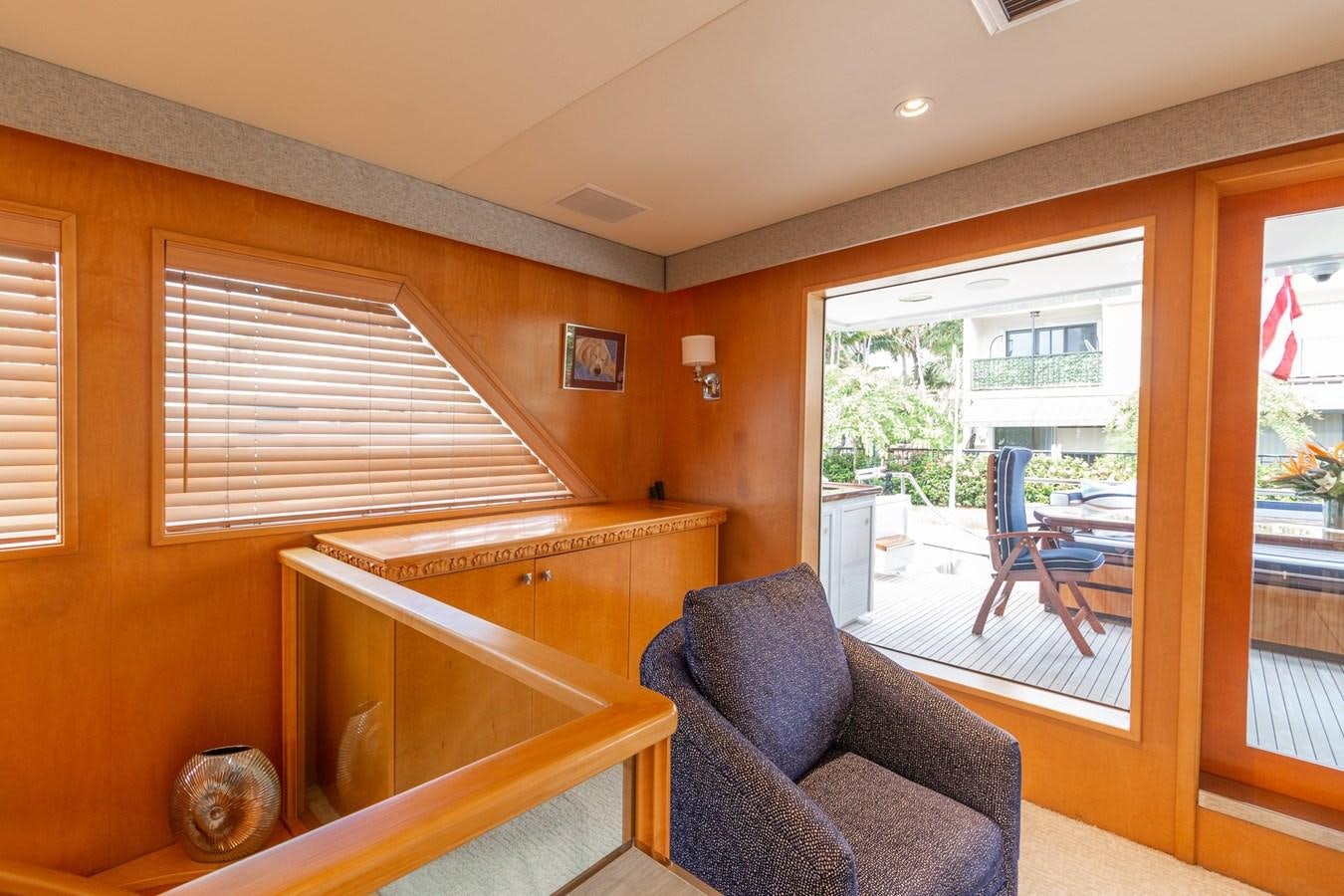 a room with a chair and a table and a window aboard UNLEASHED Yacht for Sale