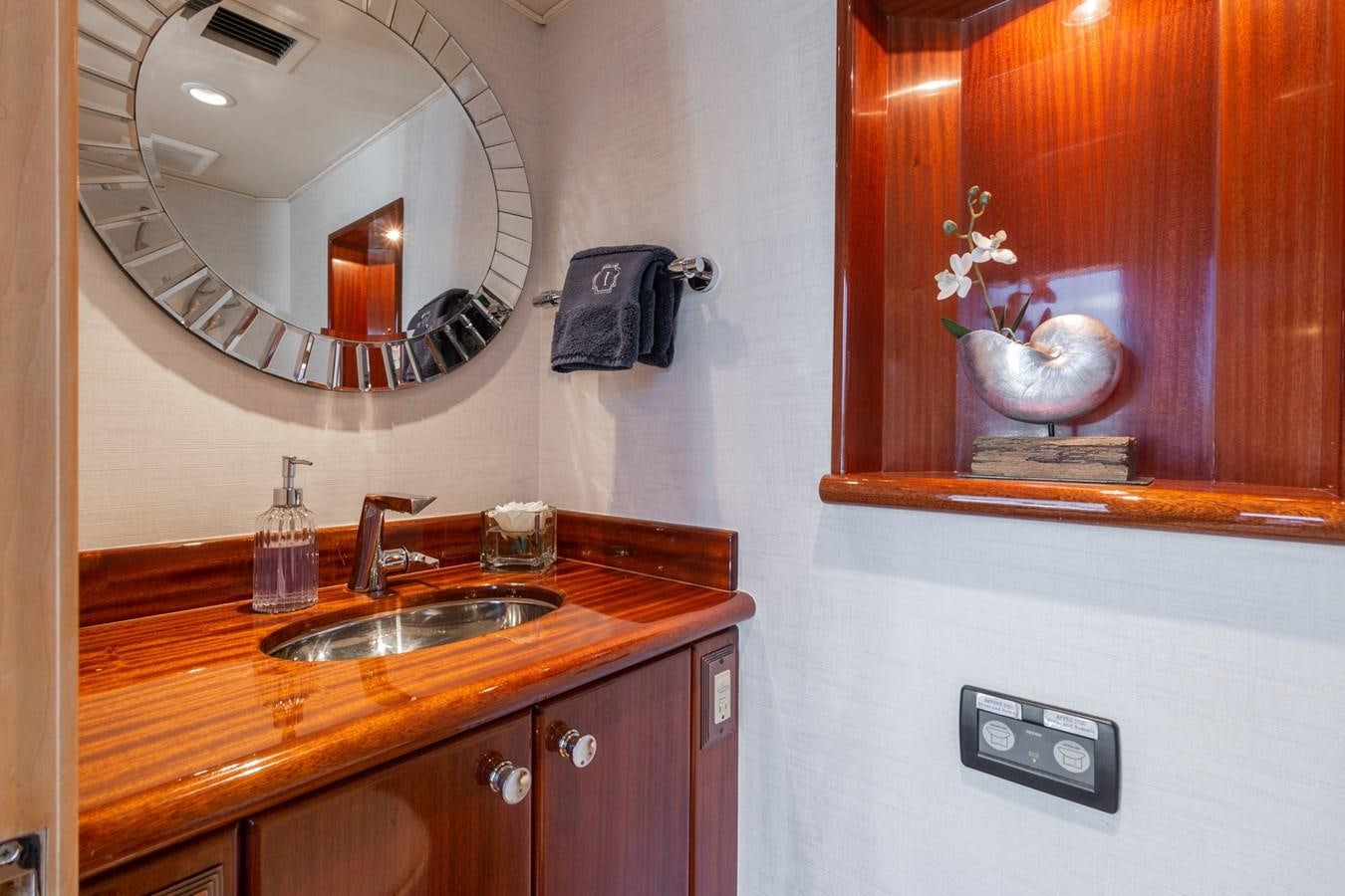 a bathroom with a round mirror aboard UNLEASHED Yacht for Sale