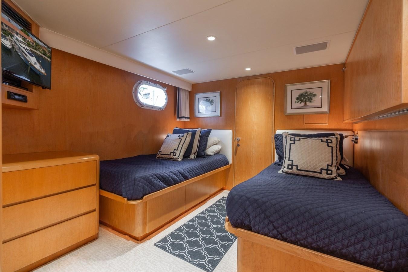 a room with a bed and a tv aboard UNLEASHED Yacht for Sale