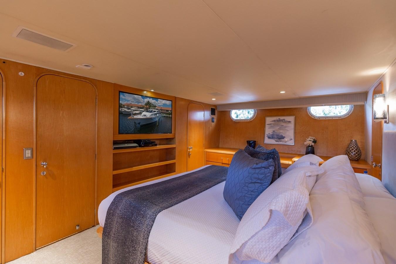 a bedroom with a bed and a television aboard UNLEASHED Yacht for Sale