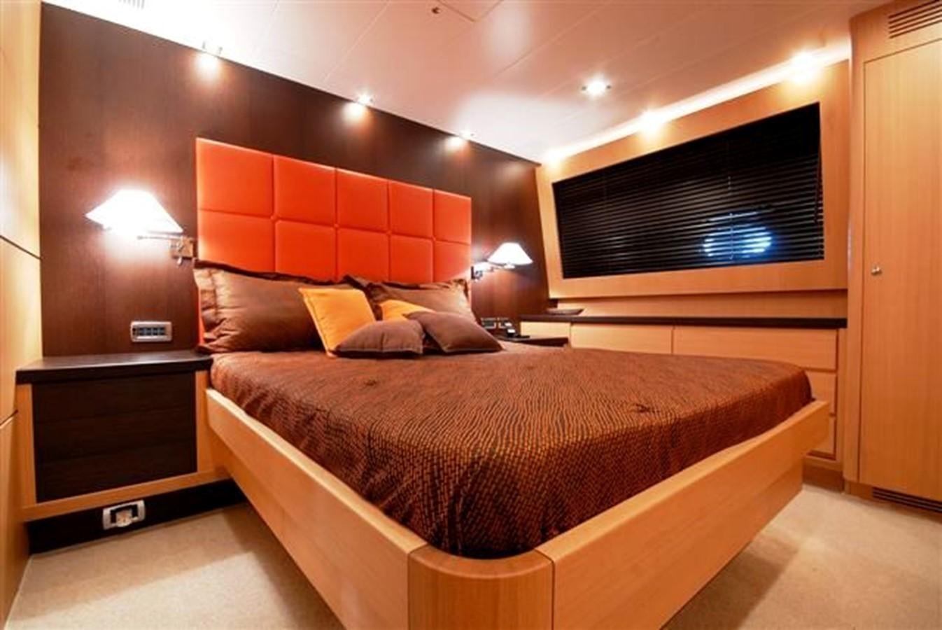 a bed with a brown and white bed spread aboard CANADOS 86 Yacht for Sale
