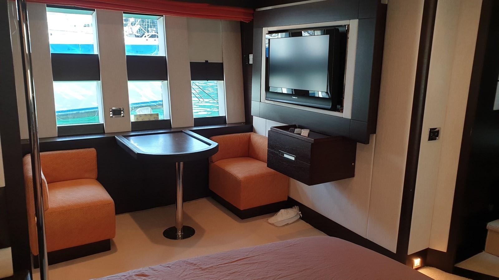 a living room with a tv and a table aboard MR LEO Yacht for Sale