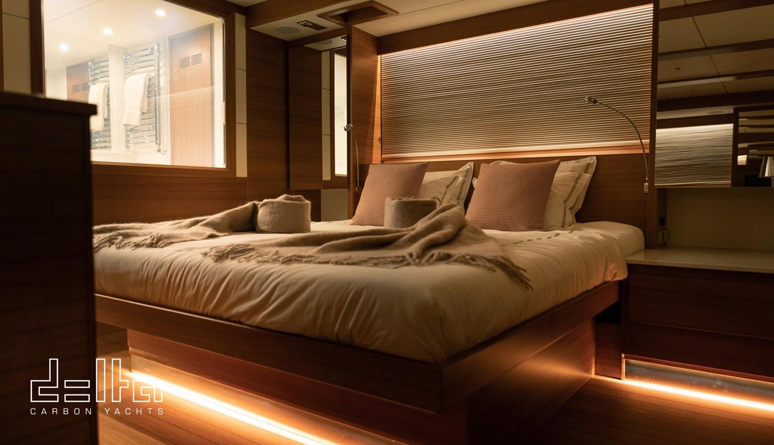 a bed with a white comforter aboard DELTA 88 CARBON Yacht for Sale