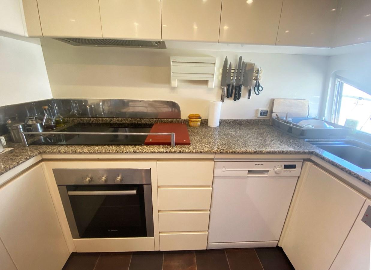 a kitchen with white cabinets aboard GRAN FINALE II Yacht for Sale