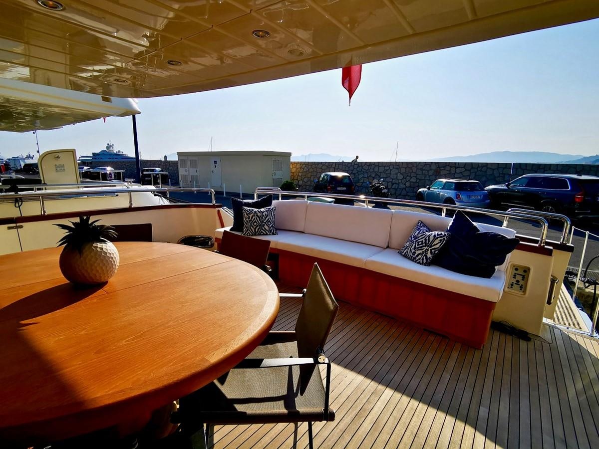 a deck with a couch and a table with chairs on it aboard V BOYS Yacht for Sale